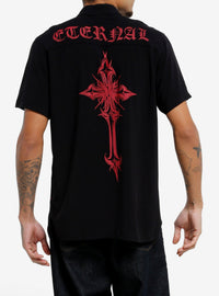 Camisa negra abotonada con cruces góticas y texto rojo