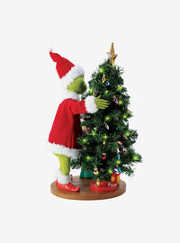 Figura del Grinch arreglando la luz del árbol
