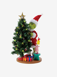 Figura del Grinch arreglando las luces del árbol
