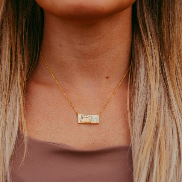 Collar con dije de librito de entradas de Disneyland