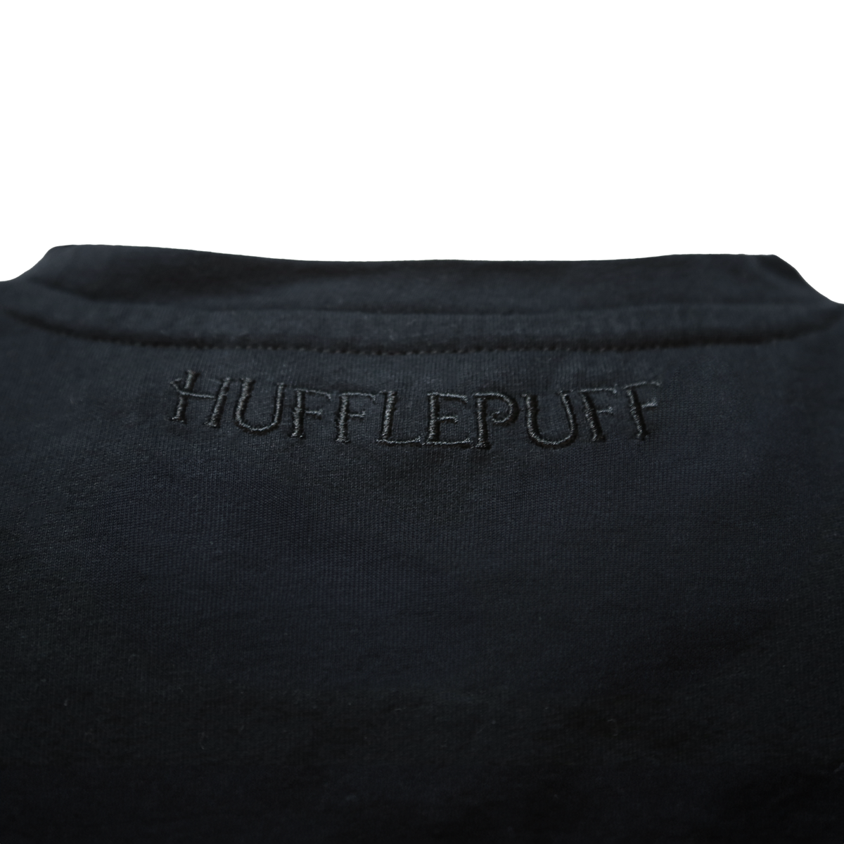 Polera negra con emblema Hufflepuff
