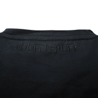Polera negra con emblema Hufflepuff